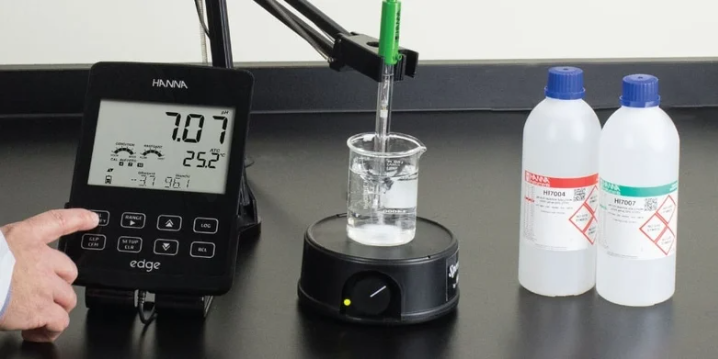 digital pH meter electrode placed in buffer solution during calibration