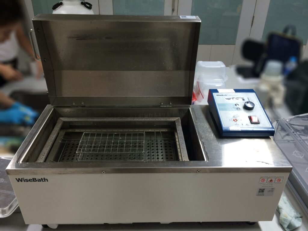 laboratory water bath used for incubation of biological samples with tube rack inside